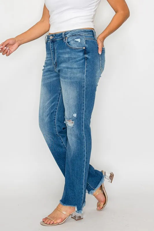 Person wearing blue jeans and a white top on a plain background