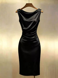 Black dress on a hanger against a neutral background
