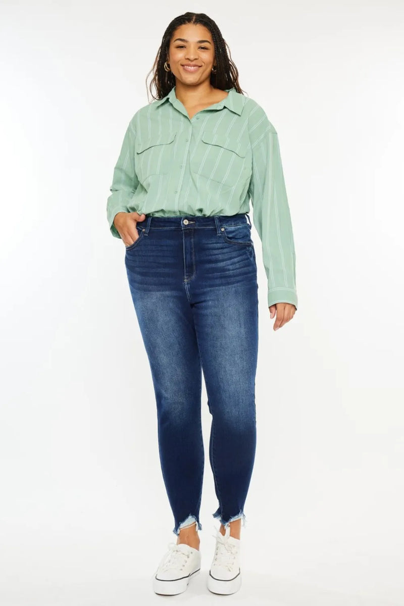 Person wearing a light green shirt and blue jeans on a white background