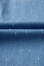 Close-up of blue denim fabric with white specks