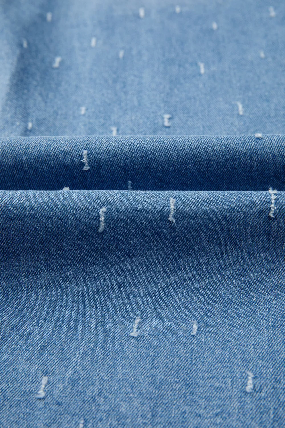 Close-up of blue denim fabric with white specks