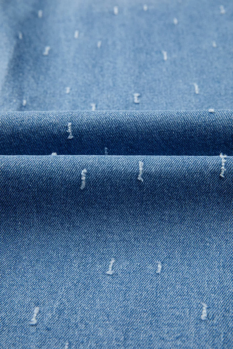 Close-up of blue denim fabric with white specks