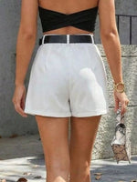 Person wearing a black top and white shorts with a blurred background
