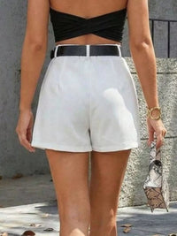 Person wearing a black top and white shorts with a blurred background