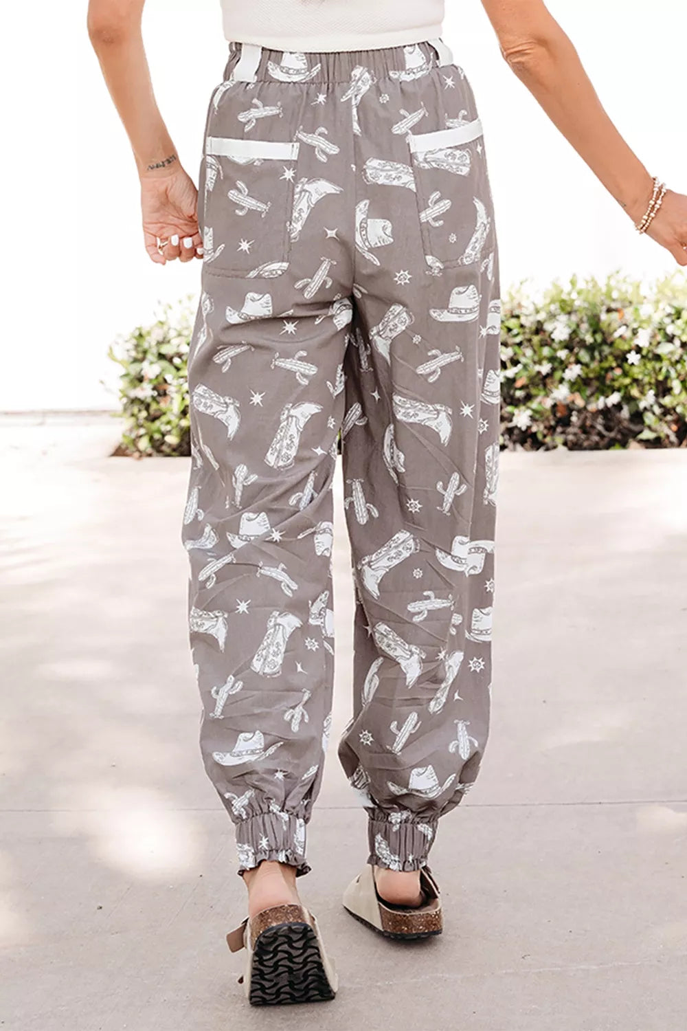 Person wearing gray pants with white patterns on a light background