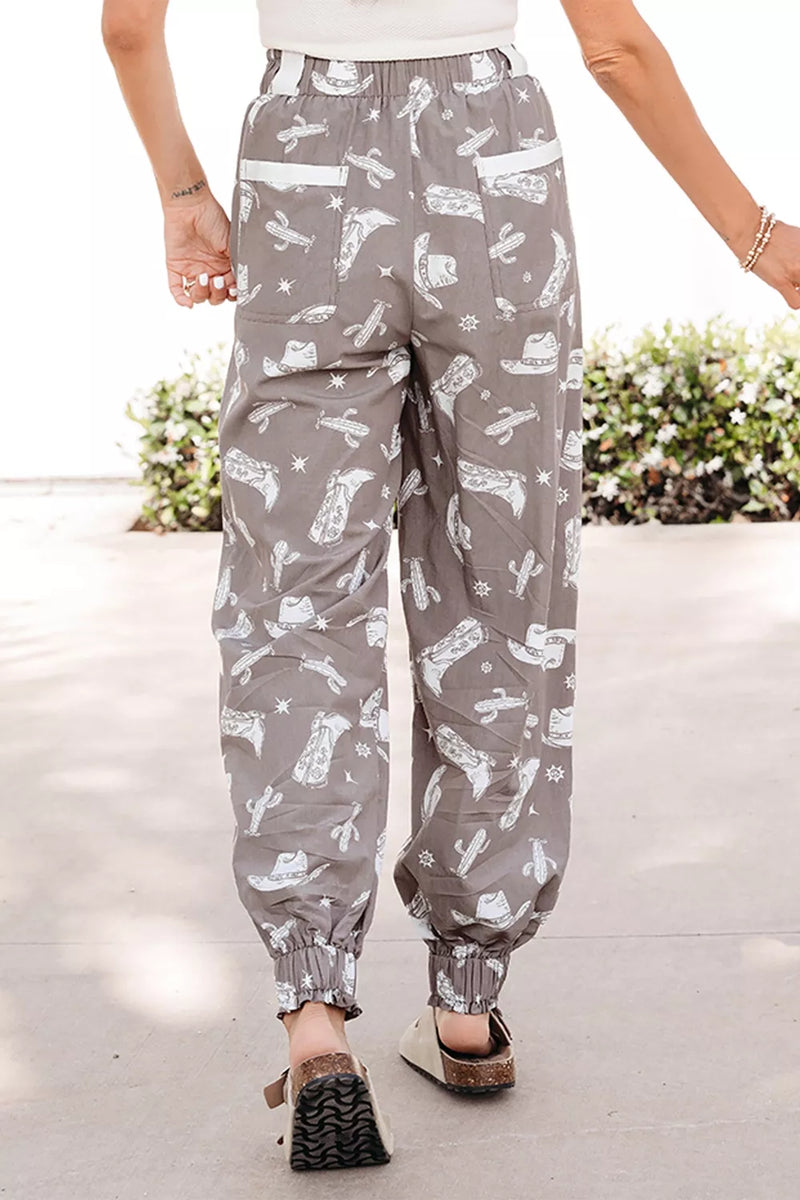 Person wearing gray pants with white patterns on a light background