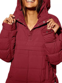 Person wearing a red puffer jacket with a hood on a white background