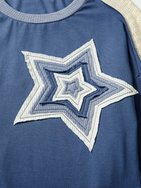 Blue shirt with a star-shaped design on a plain background