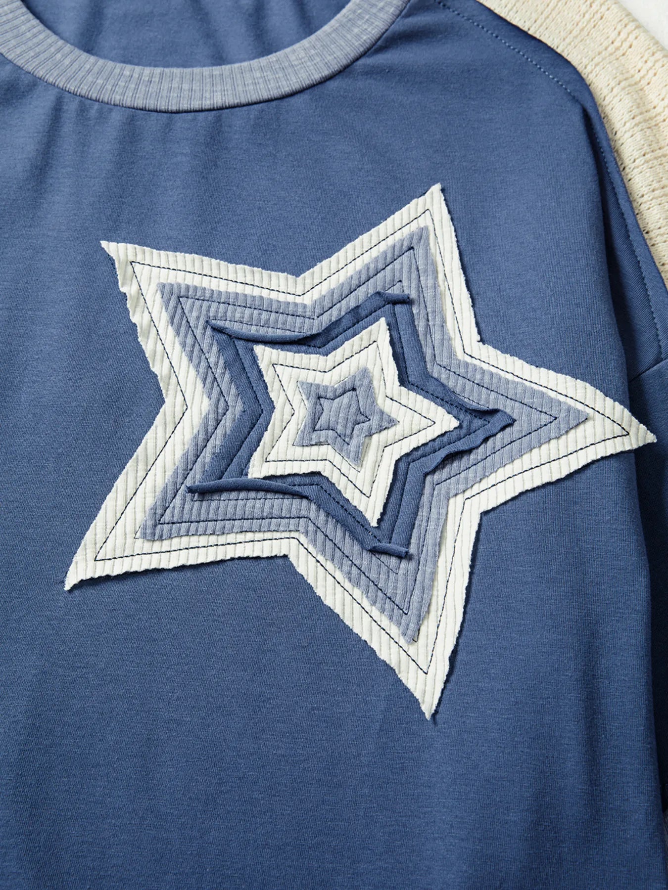 Blue shirt with a star-shaped design on a plain background