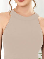 Close-up of a beige halter top worn by a person with a blurred background