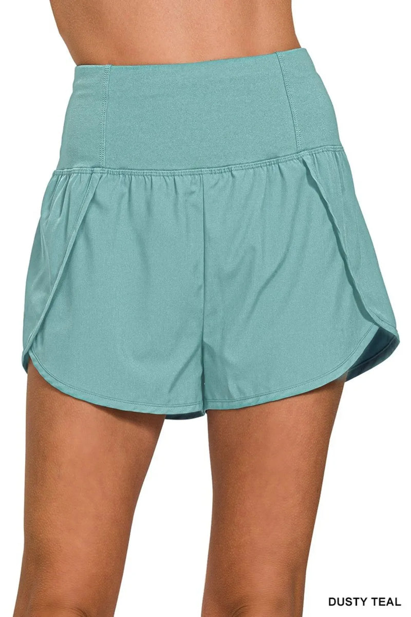 Teal shorts worn by a person on a white background