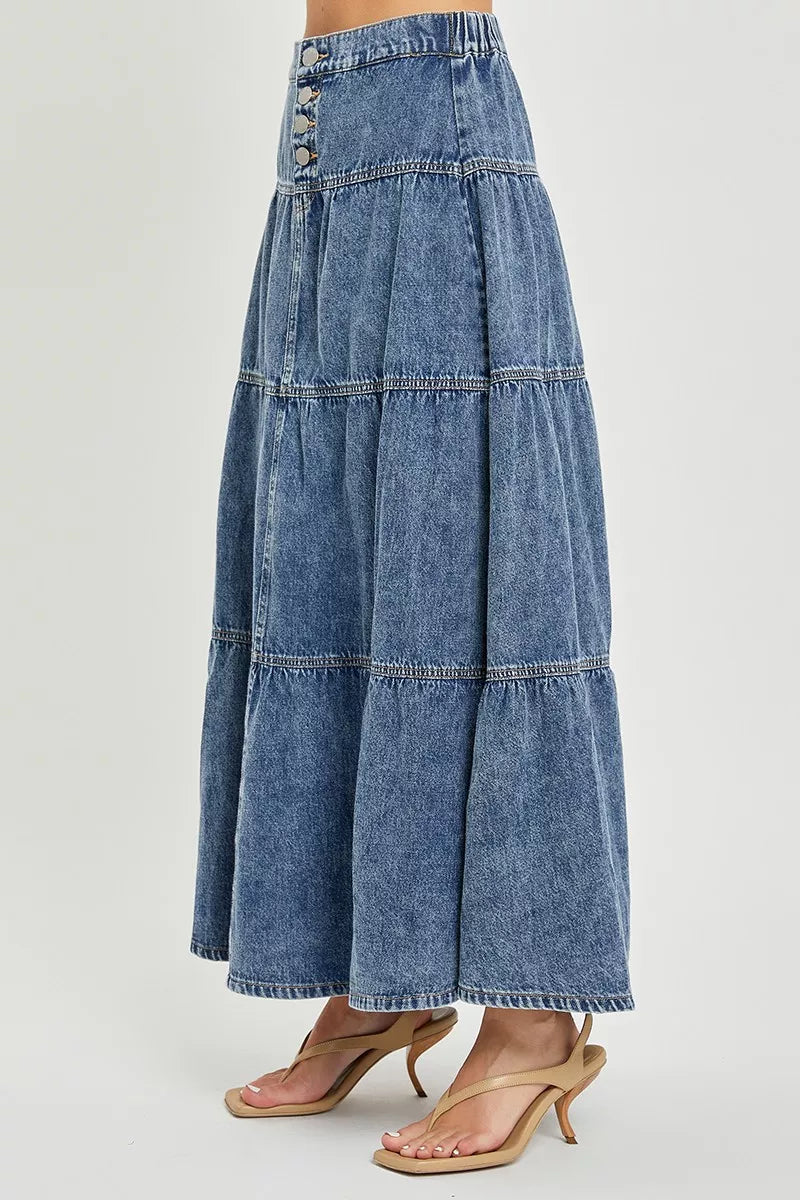 Long denim skirt worn by a person on a light gray background