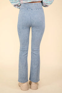 Light blue jeans worn by a person on a beige background