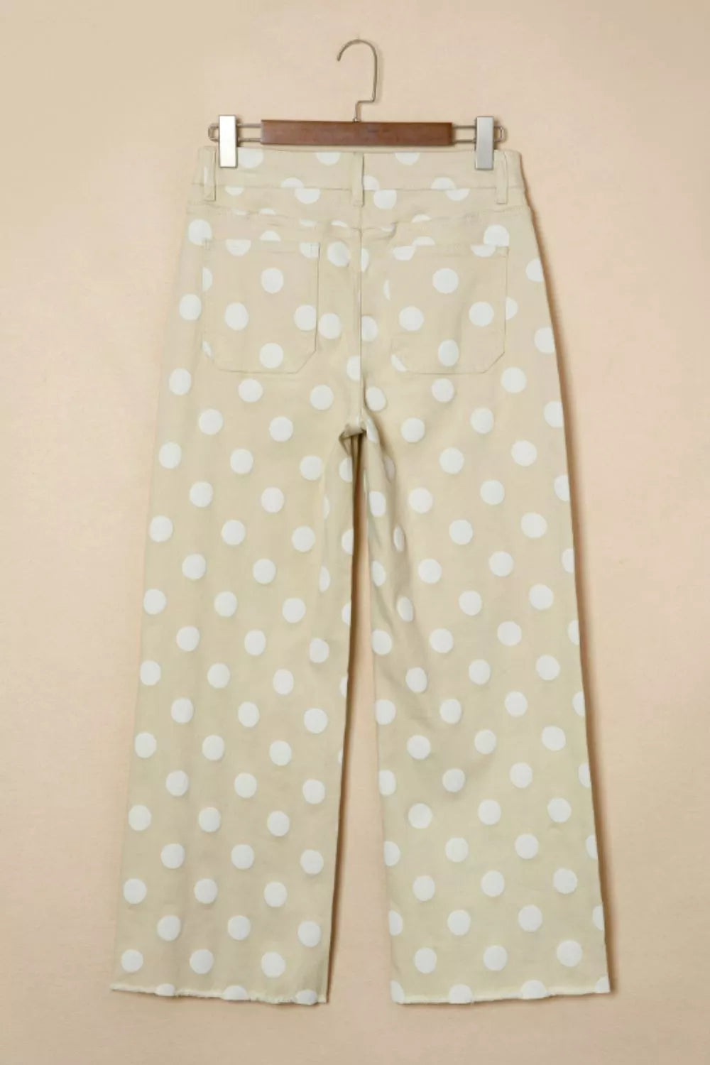 Polka dot pants hanging on a beige background