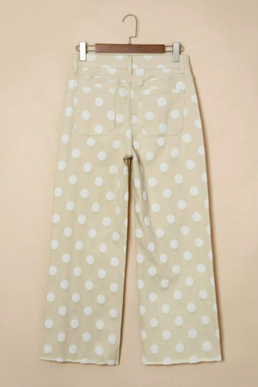 Polka dot pants hanging on a beige background