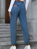 Person wearing blue jeans standing on stone steps.