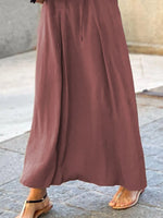 Brown wide-leg pants worn by a person on a stone pavement.