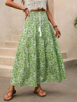 Person wearing a green patterned skirt with a neutral background