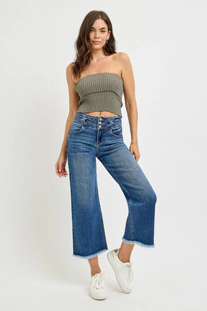Woman wearing a strapless top and wide-leg jeans on a white background