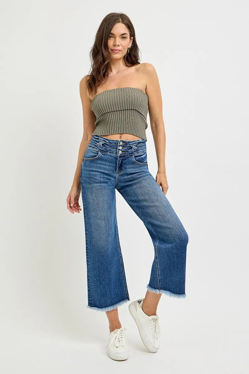 Woman wearing a strapless top and wide-leg jeans on a white background