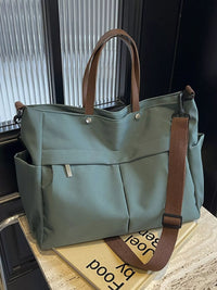 Green tote bag with brown straps on a wooden surface