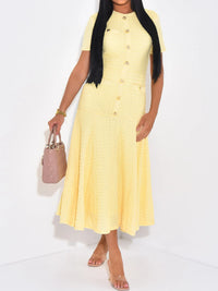 Woman wearing a yellow dress holding a pink handbag on a white background