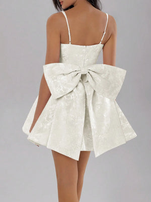 White dress with a large bow detail on a gray background
