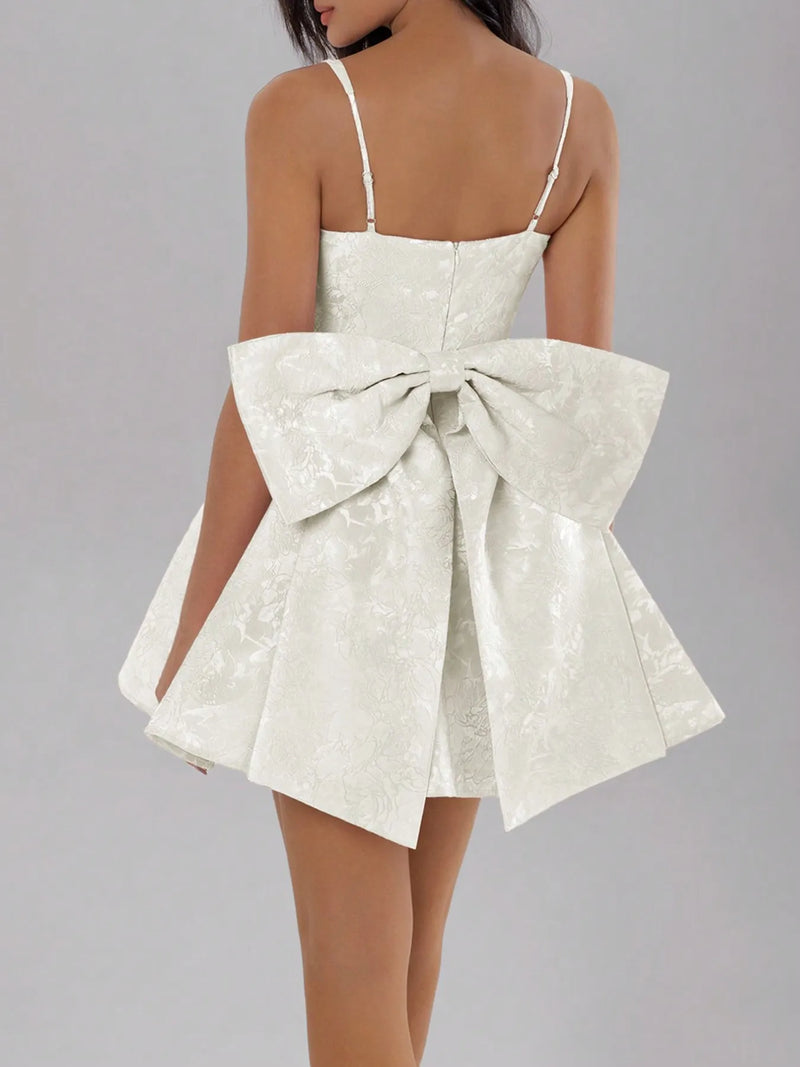 White dress with a large bow detail on a gray background