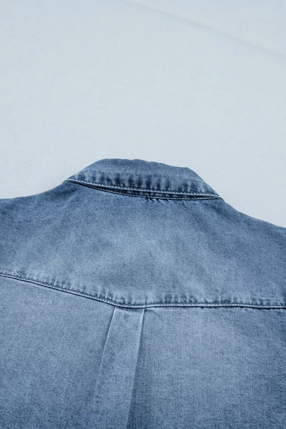 Blue denim jacket on a light gray background