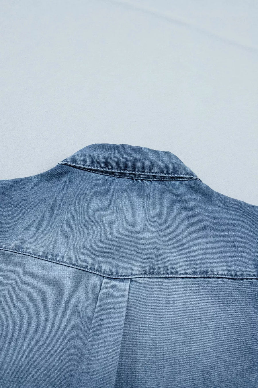 Blue denim jacket on a light gray background