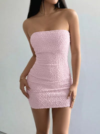 Pink strapless dress worn by a person on a plain background