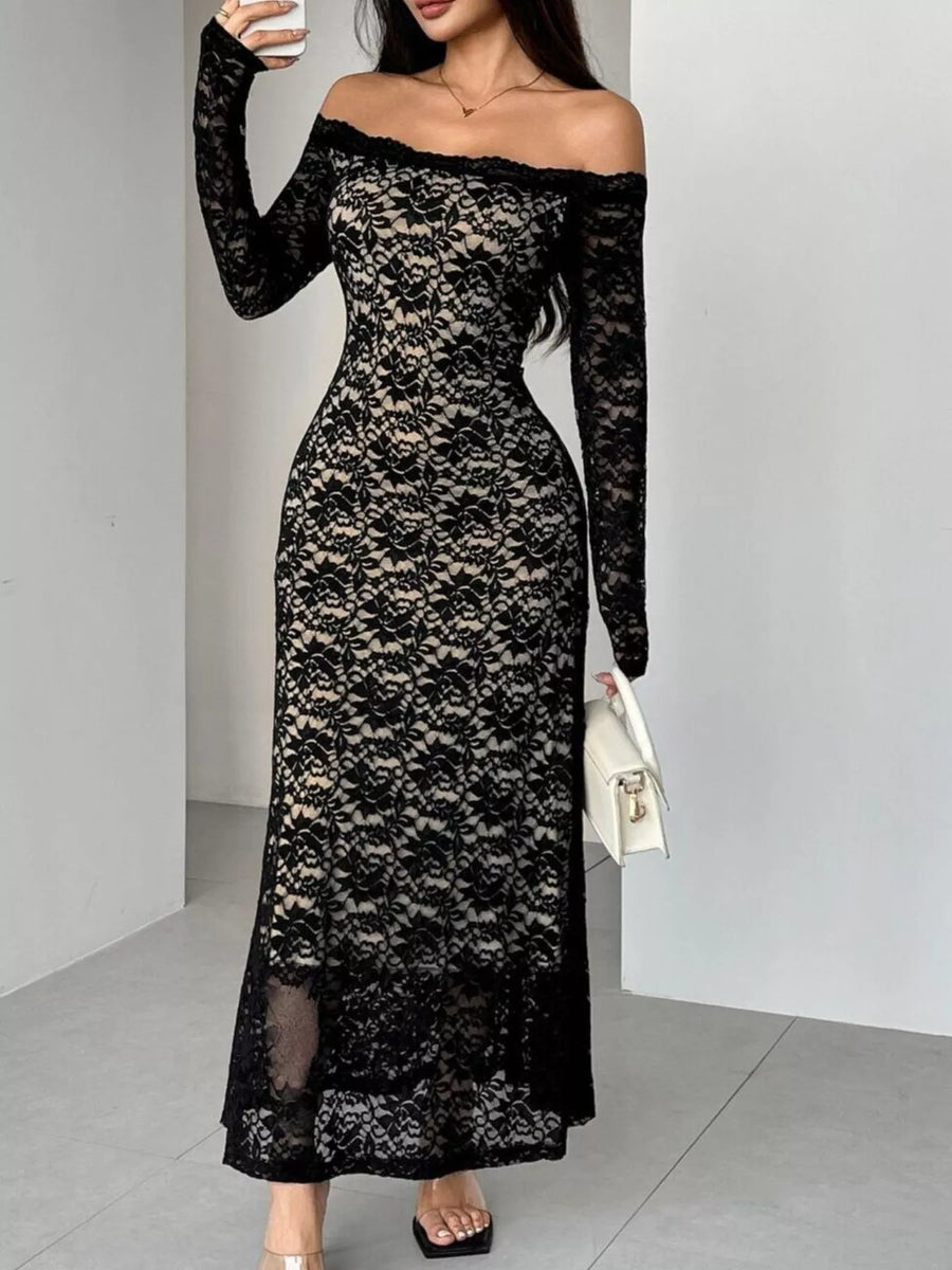 Woman wearing a black lace off-shoulder dress against a plain background