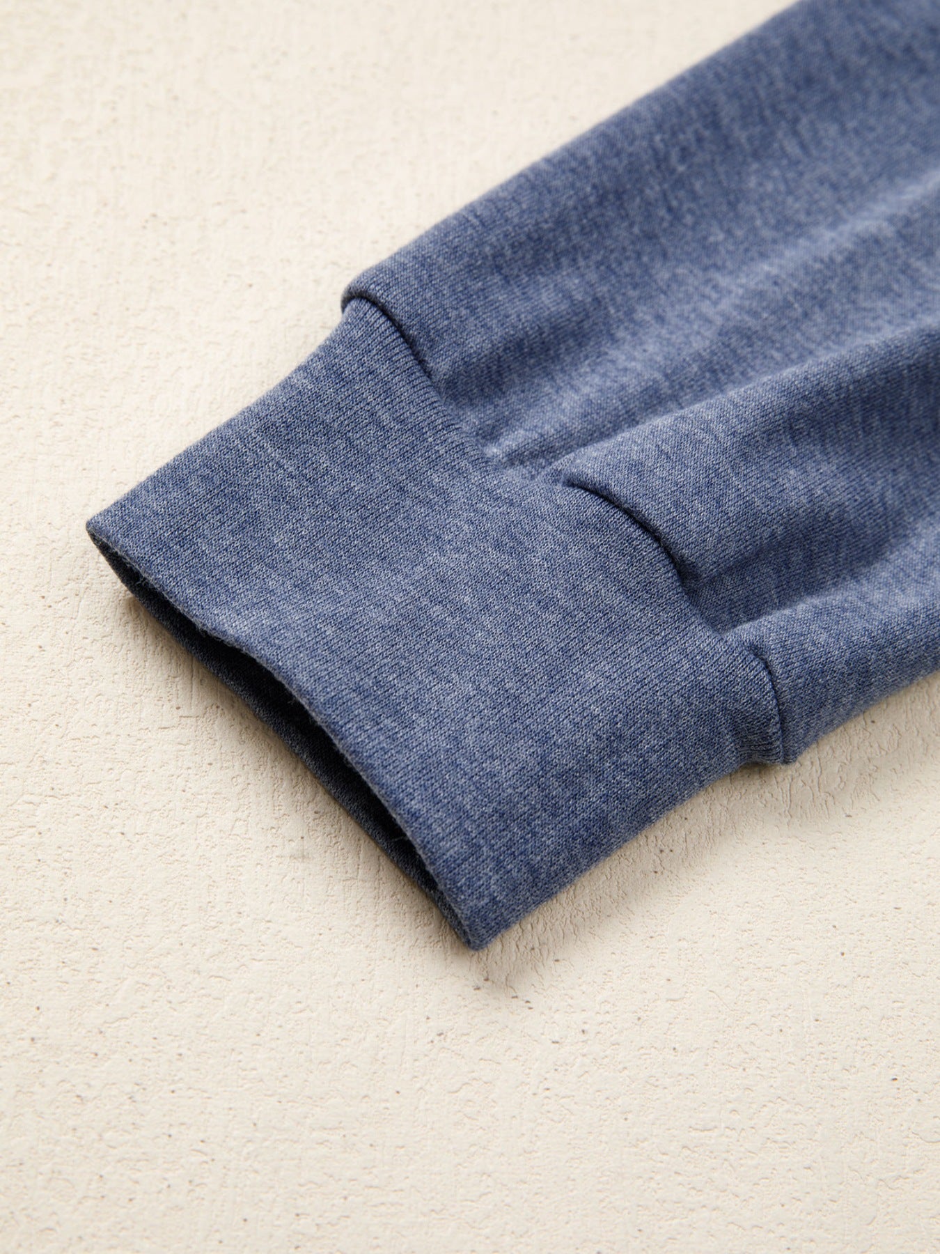 Close-up of a blue fabric sleeve on a beige background