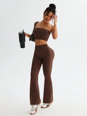 Woman wearing a brown outfit holding a black tumbler on a white background