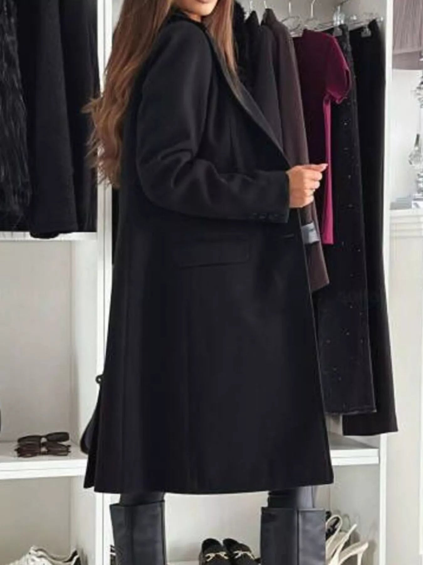 Person wearing a black coat in a clothing store