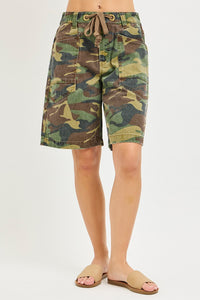 Camouflage shorts worn by a person on a white background