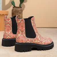 Patterned boots with black soles on a light surface