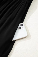 Close-up of a smartphone with a black curtain in the background