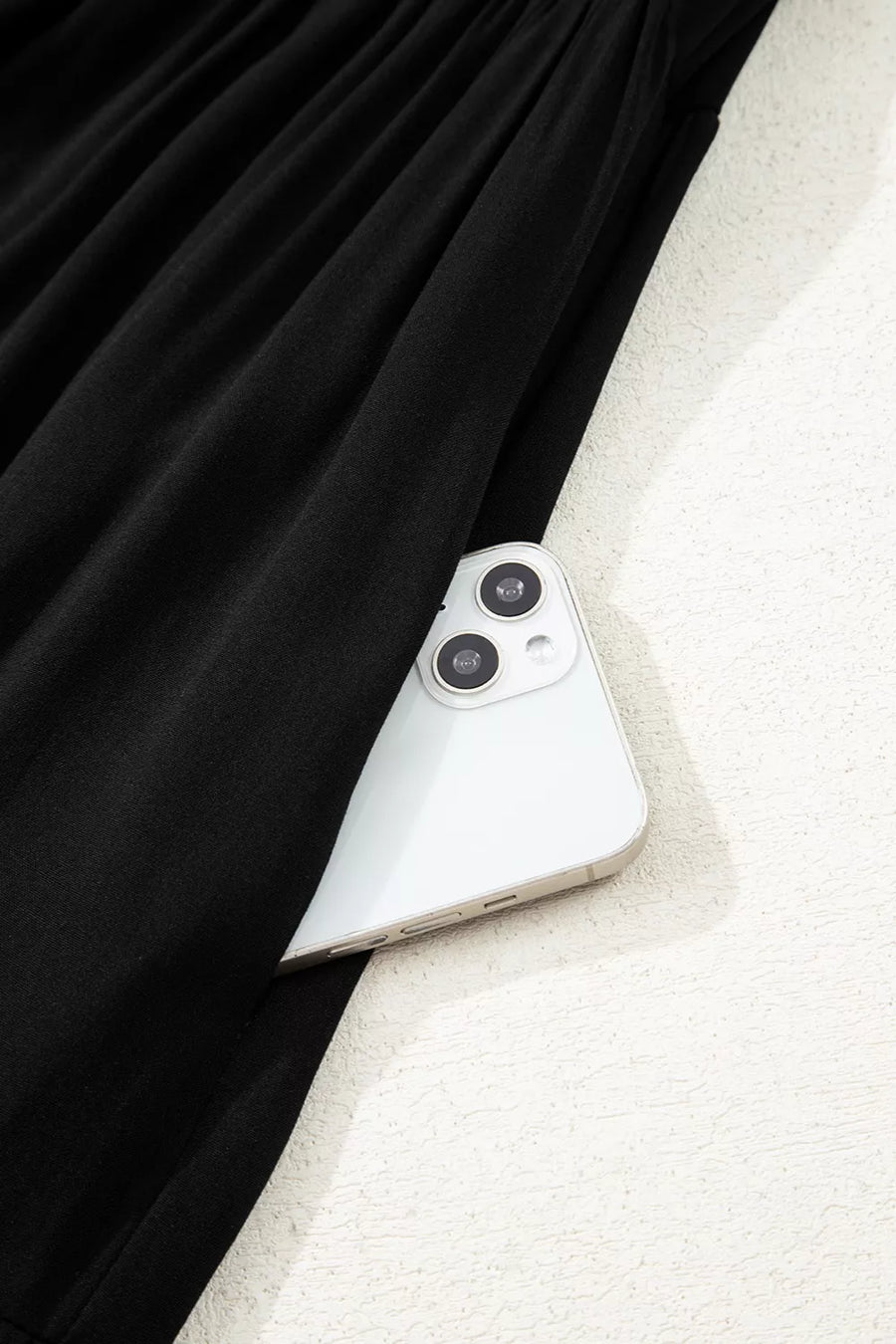 Close-up of a smartphone with a black curtain in the background