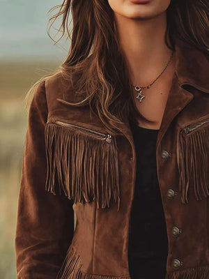 Person wearing a brown suede jacket with fringe details, standing outdoors.