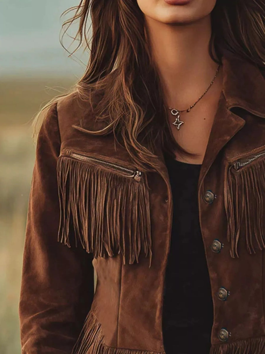 Person wearing a brown suede jacket with fringe details, standing outdoors.