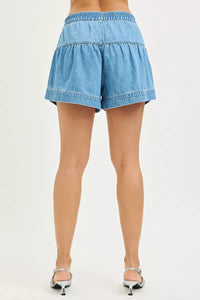 Blue denim shorts worn by a person on a white background