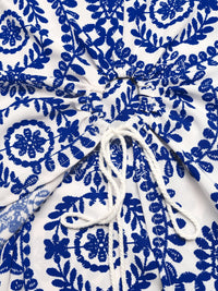White fabric with blue floral patterns and a white drawstring.