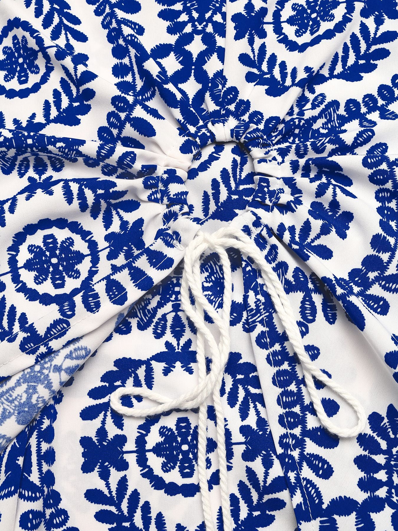 White fabric with blue floral patterns and a white drawstring.