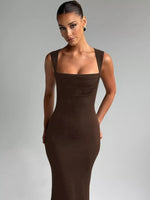 Woman wearing a brown dress against a gray background