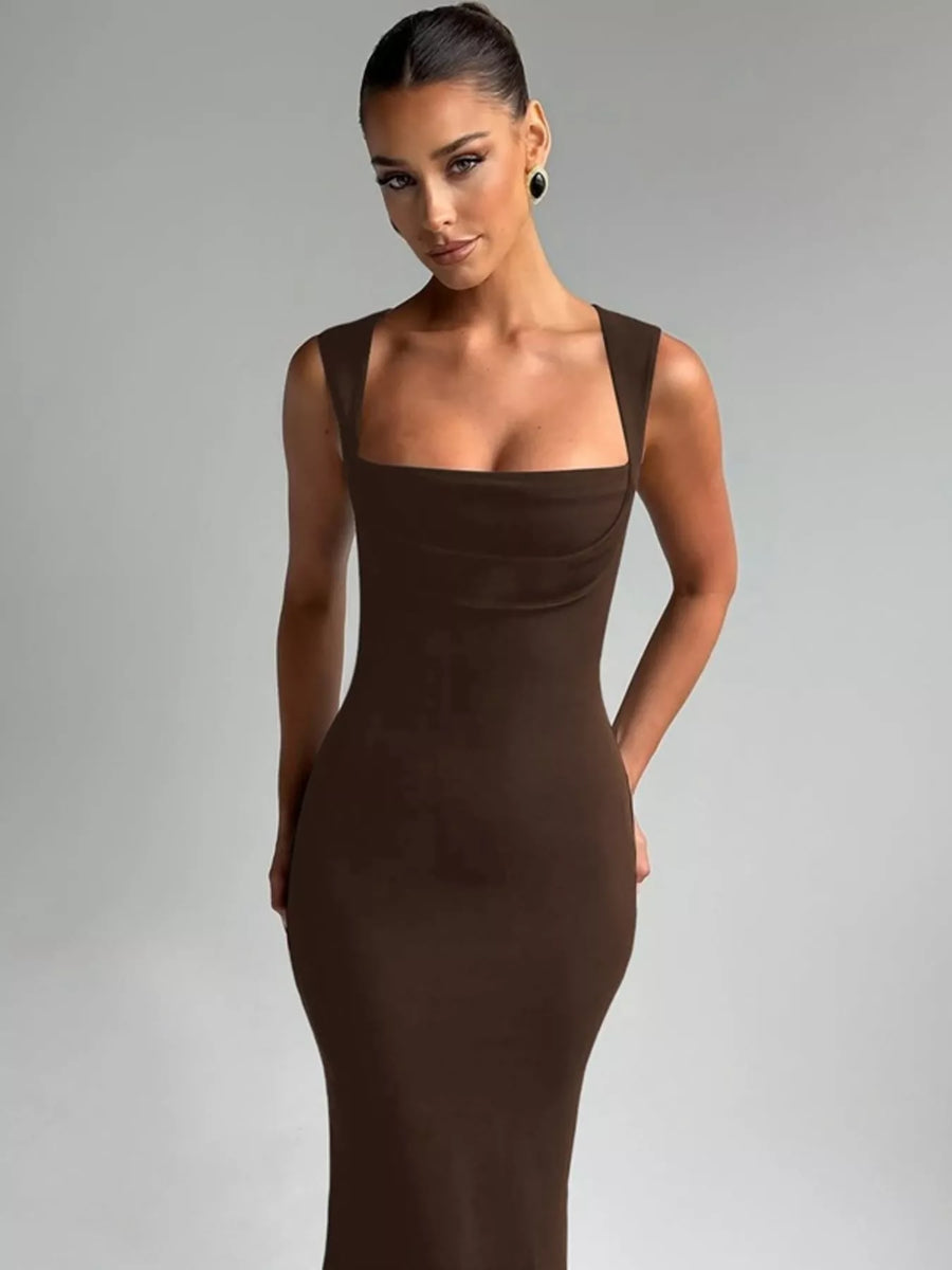 Woman wearing a brown dress against a gray background