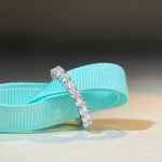 Silver ring with small diamonds on a turquoise ribbon