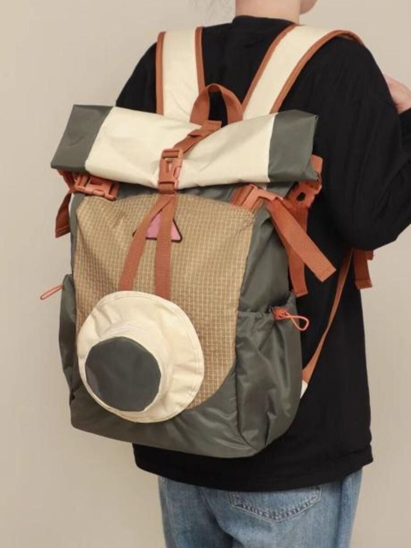Person wearing a multicolored backpack with a neutral background