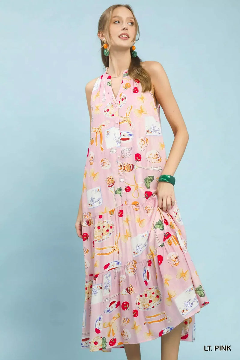Woman wearing a light pink dress with colorful patterns on a light blue background