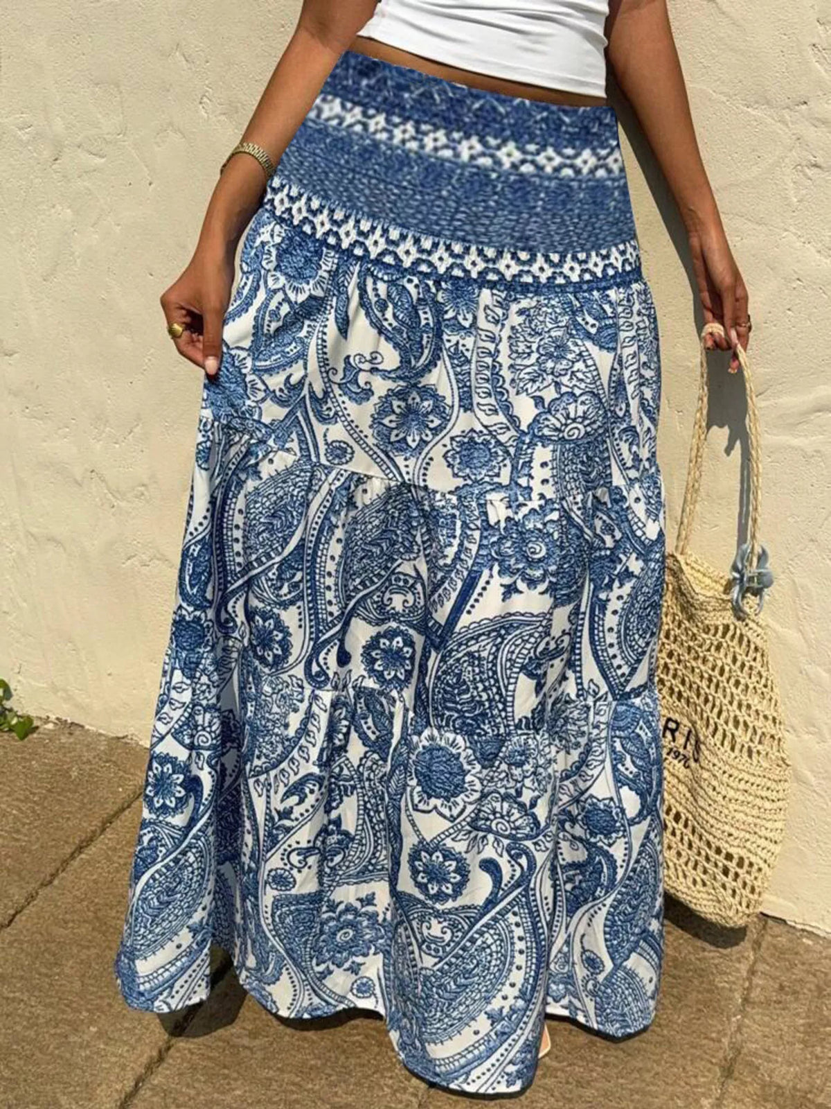 Person wearing a blue and white patterned skirt with a beige background